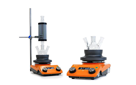 Two hotplates. The one on the left is set up with heat-on and findenser and the one on the right is set up with just heat-on